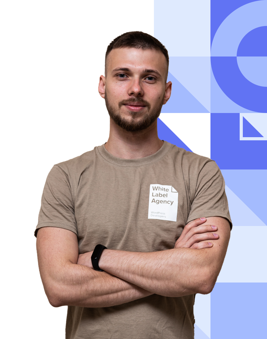 A man with a beard, wearing a beige "White Label Agency" t-shirt, posing with arms crossed.